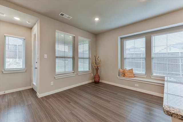 unfurnished room with hardwood / wood-style floors and a healthy amount of sunlight