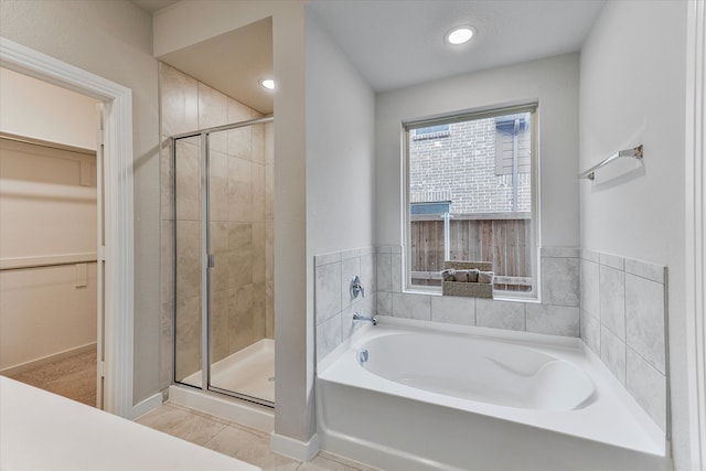 bathroom featuring tile patterned floors and independent shower and bath