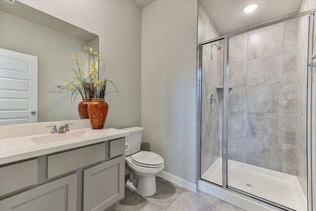 bathroom featuring vanity, tile patterned flooring, toilet, a textured ceiling, and an enclosed shower