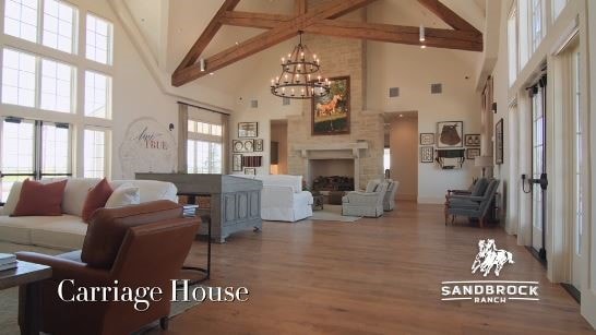 living room featuring a healthy amount of sunlight, wood-type flooring, beam ceiling, and high vaulted ceiling