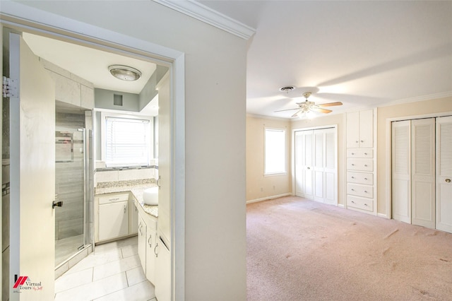 interior space with ceiling fan and crown molding