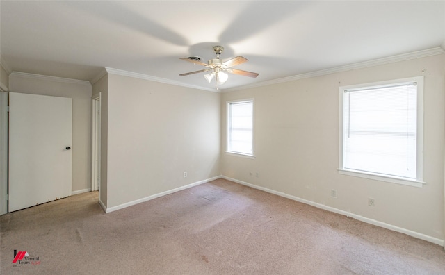 empty room featuring crown molding, light colored carpet, and a healthy amount of sunlight