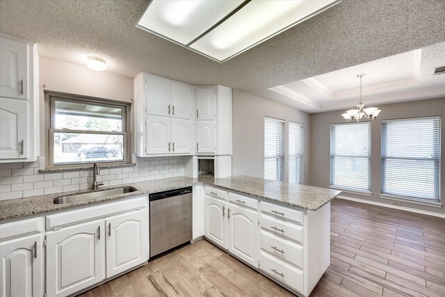 kitchen with white cabinets, dishwasher, kitchen peninsula, and a wealth of natural light