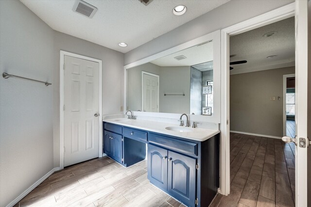 bathroom featuring hardwood / wood-style floors, plenty of natural light, ceiling fan, and vanity