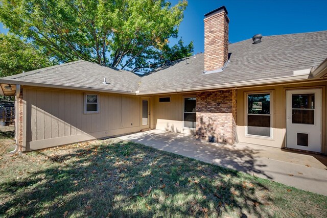 rear view of house featuring a patio and a lawn