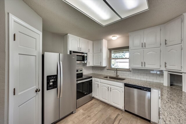 kitchen with sink, white cabinets, and stainless steel appliances