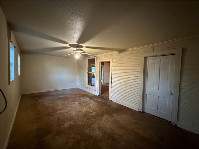 unfurnished bedroom with ceiling fan, a textured ceiling, and dark colored carpet