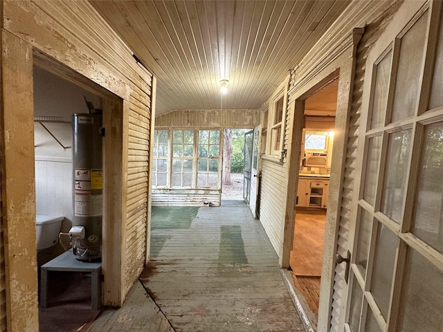 hallway with lofted ceiling, hardwood / wood-style flooring, wooden ceiling, and water heater