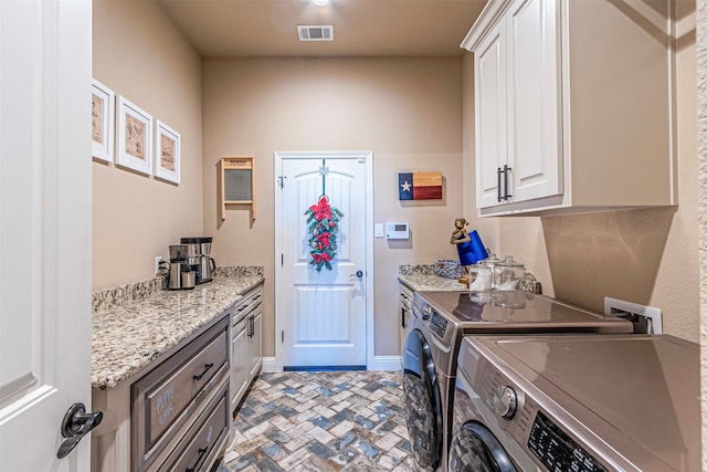 washroom with cabinets and washing machine and dryer