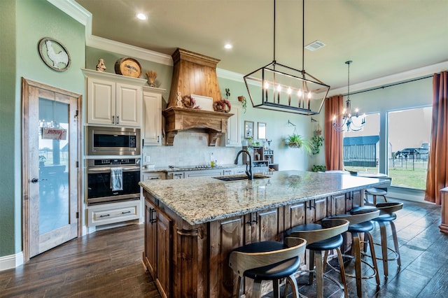 kitchen with pendant lighting, sink, appliances with stainless steel finishes, dark hardwood / wood-style flooring, and a chandelier