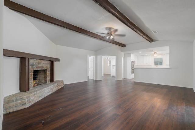 unfurnished living room featuring ceiling fan, lofted ceiling with beams, dark hardwood / wood-style floors, and a brick fireplace