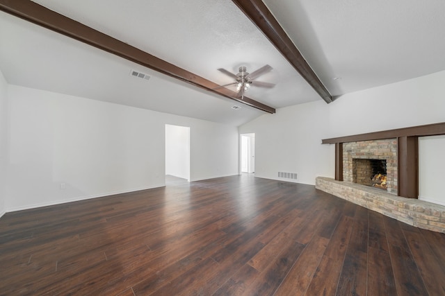 unfurnished living room featuring lofted ceiling with beams, ceiling fan, dark wood-type flooring, and a brick fireplace