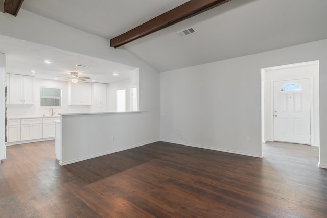 unfurnished living room with vaulted ceiling with beams, ceiling fan, dark hardwood / wood-style flooring, and sink