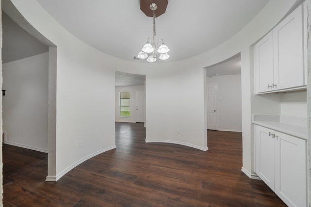 unfurnished dining area featuring dark hardwood / wood-style flooring and a chandelier