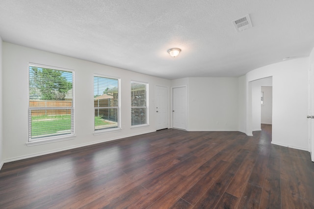 unfurnished room featuring a textured ceiling and dark wood-type flooring