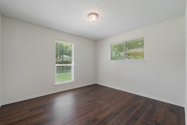 empty room featuring dark hardwood / wood-style flooring and a textured ceiling