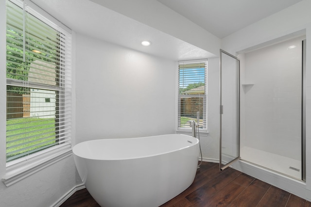 bathroom featuring wood-type flooring and separate shower and tub