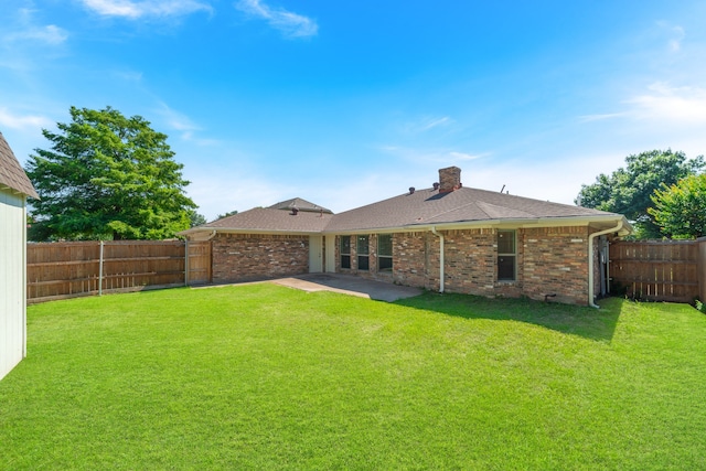 rear view of property with a lawn and a patio