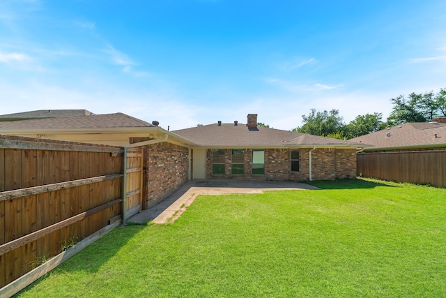 back of house featuring a lawn and a patio