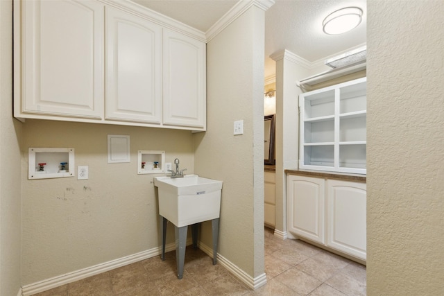 clothes washing area with crown molding, hookup for a washing machine, cabinet space, a textured wall, and baseboards