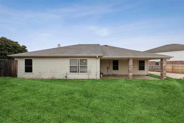 back of house featuring a lawn and fence