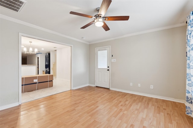 empty room with visible vents, crown molding, and light wood-style flooring