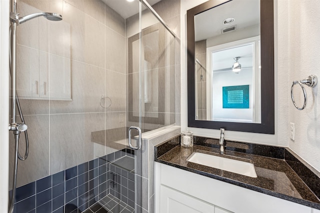 bathroom featuring vanity and a shower with door