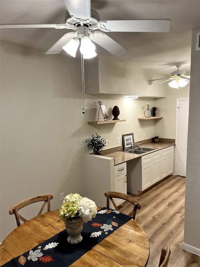 dining area featuring light wood-type flooring and sink