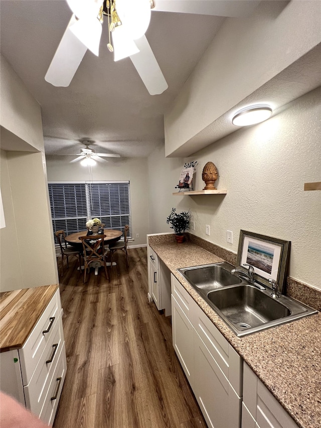 kitchen featuring dark hardwood / wood-style flooring, white cabinetry, butcher block counters, and sink