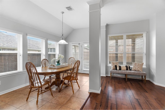 dining space featuring wood-type flooring and vaulted ceiling