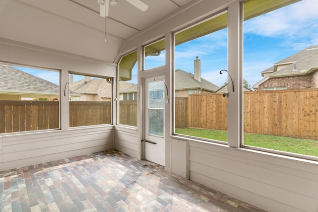 unfurnished sunroom featuring ceiling fan