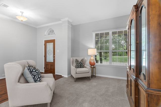 living area with carpet, ornate columns, and crown molding