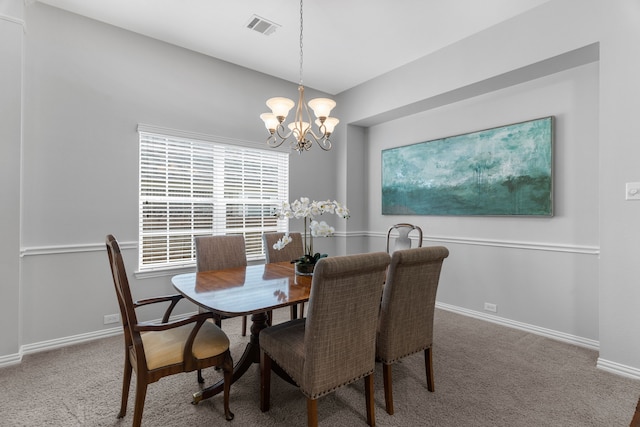 dining room with carpet floors and a notable chandelier