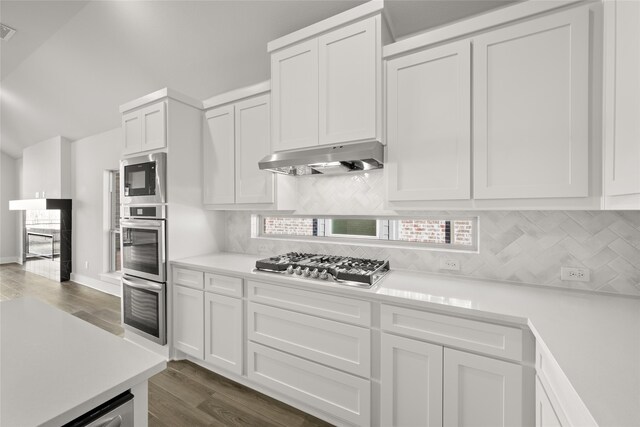 kitchen with white cabinets, appliances with stainless steel finishes, and exhaust hood