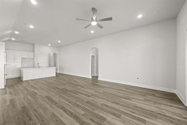 unfurnished living room featuring ceiling fan, sink, and light hardwood / wood-style flooring