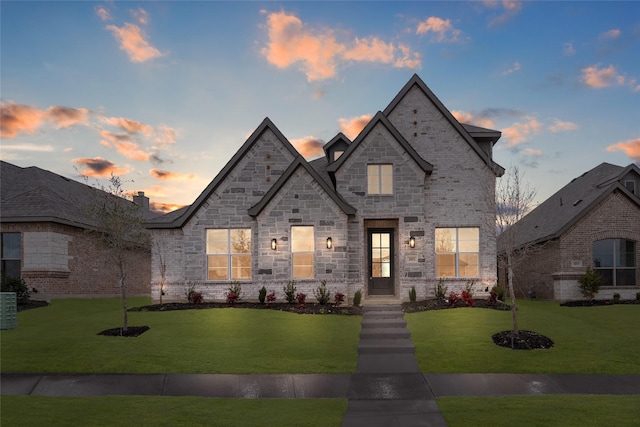 french country inspired facade featuring a yard and central air condition unit