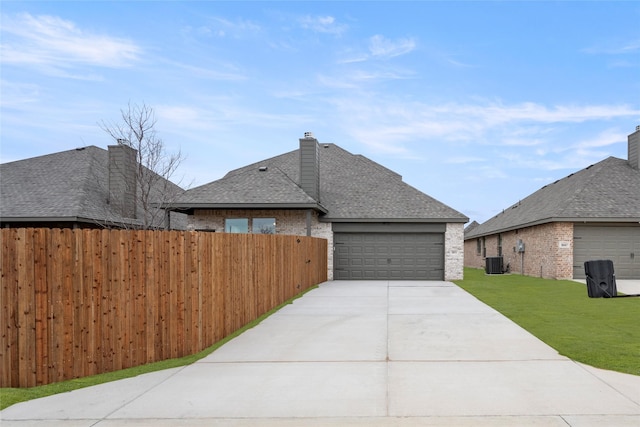 view of home's exterior with a garage, a yard, and central AC