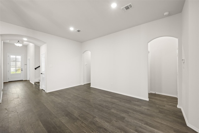 unfurnished room with dark wood-type flooring