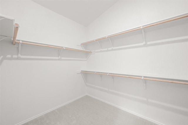 walk in closet featuring carpet floors and lofted ceiling