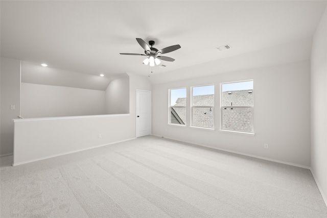 empty room with light carpet, vaulted ceiling, and ceiling fan