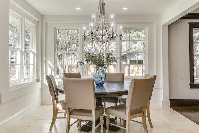 tiled dining area featuring a wealth of natural light and an inviting chandelier