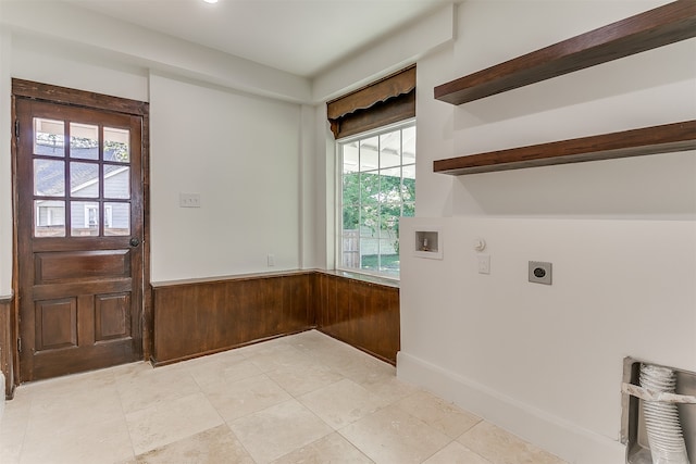 clothes washing area with hookup for an electric dryer, a healthy amount of sunlight, wood walls, and hookup for a washing machine