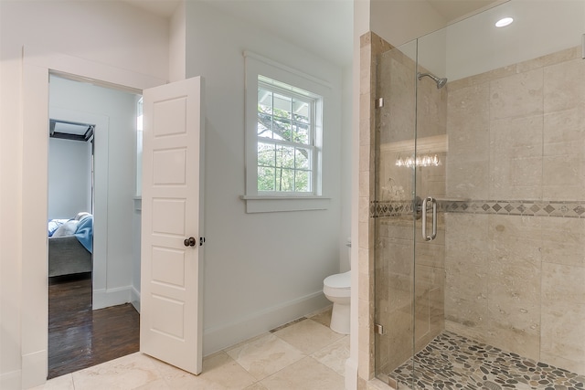 bathroom with toilet, a shower with shower door, and hardwood / wood-style flooring