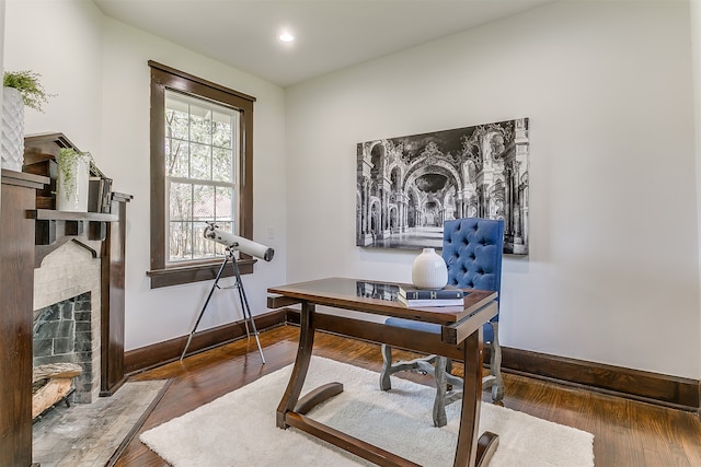 office with a fireplace and wood-type flooring