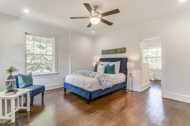 bedroom with multiple windows, ceiling fan, and dark hardwood / wood-style flooring