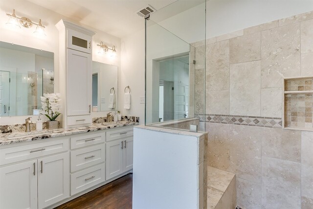 bathroom featuring tiled shower, vanity, tile walls, and hardwood / wood-style flooring