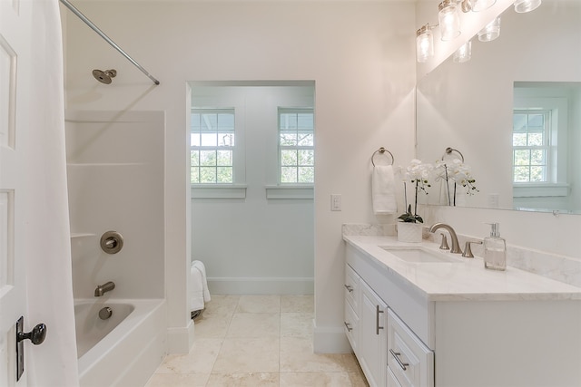 bathroom featuring tile patterned flooring, vanity, shower / tub combination, and a wealth of natural light