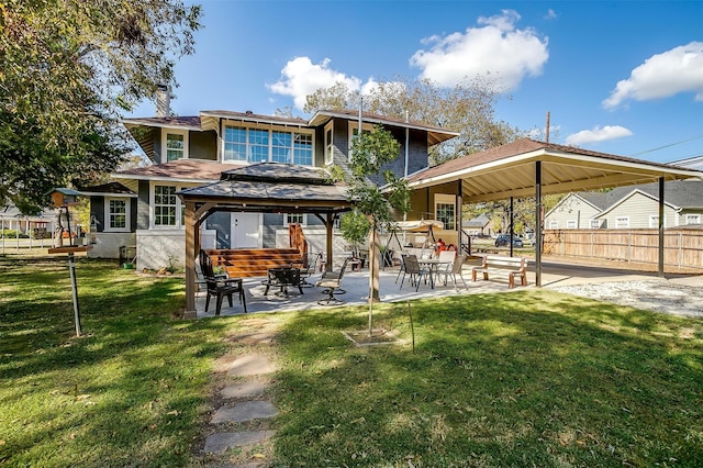 rear view of property featuring a gazebo, a patio, and a lawn