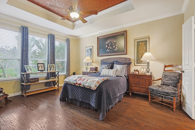 bedroom with a tray ceiling, ceiling fan, dark hardwood / wood-style floors, and ornamental molding