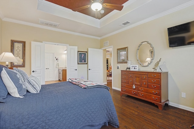 bedroom featuring ensuite bathroom, a raised ceiling, ceiling fan, crown molding, and dark wood-type flooring